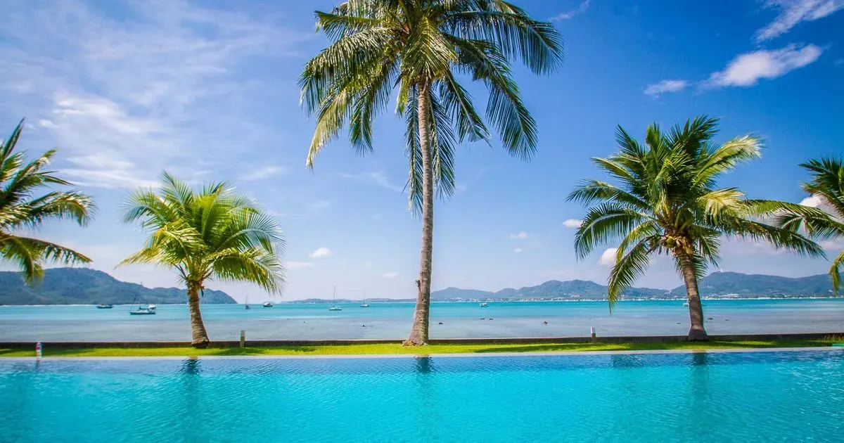 Panoramic view of the swimming pool, the golden beach, and the beautiful bay.